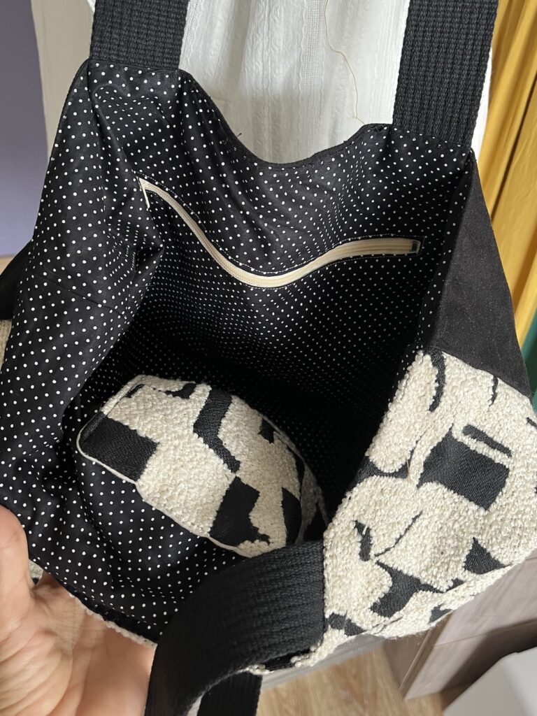 Sac avec grand compartiment contenant deux poches , une plaquée et une zippée, création locale