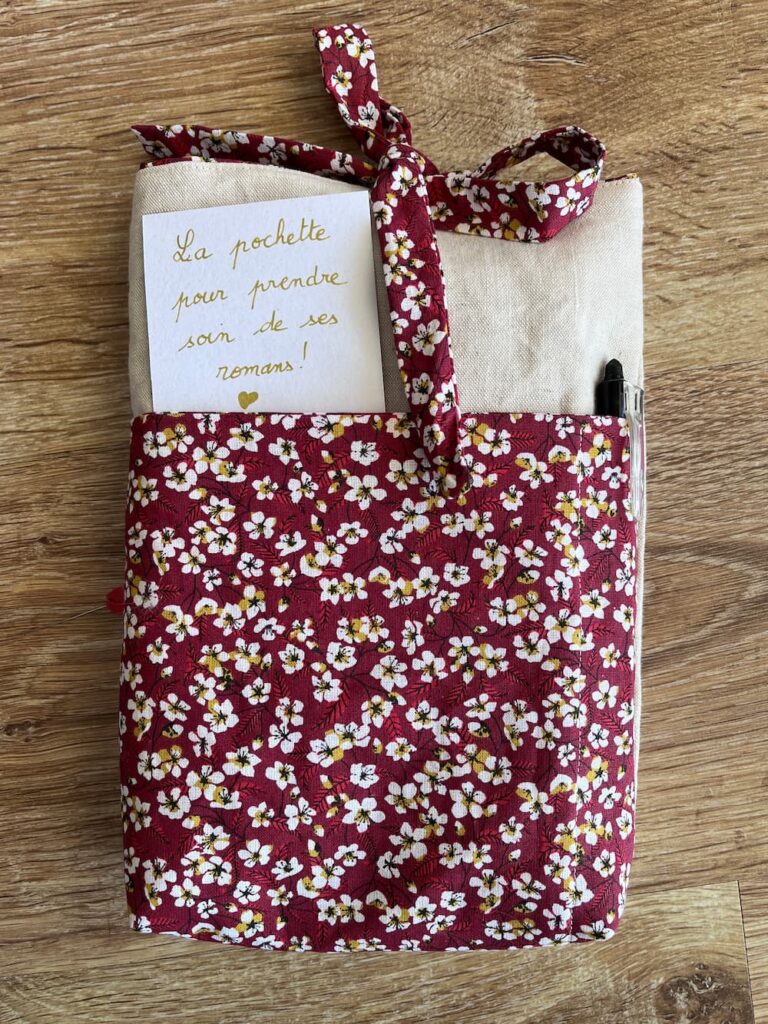 Une pochette roman à motif Liberty rouge à fleurs blanches, pour protéger ses livres lors des déplacements, fait-main à Carmaux