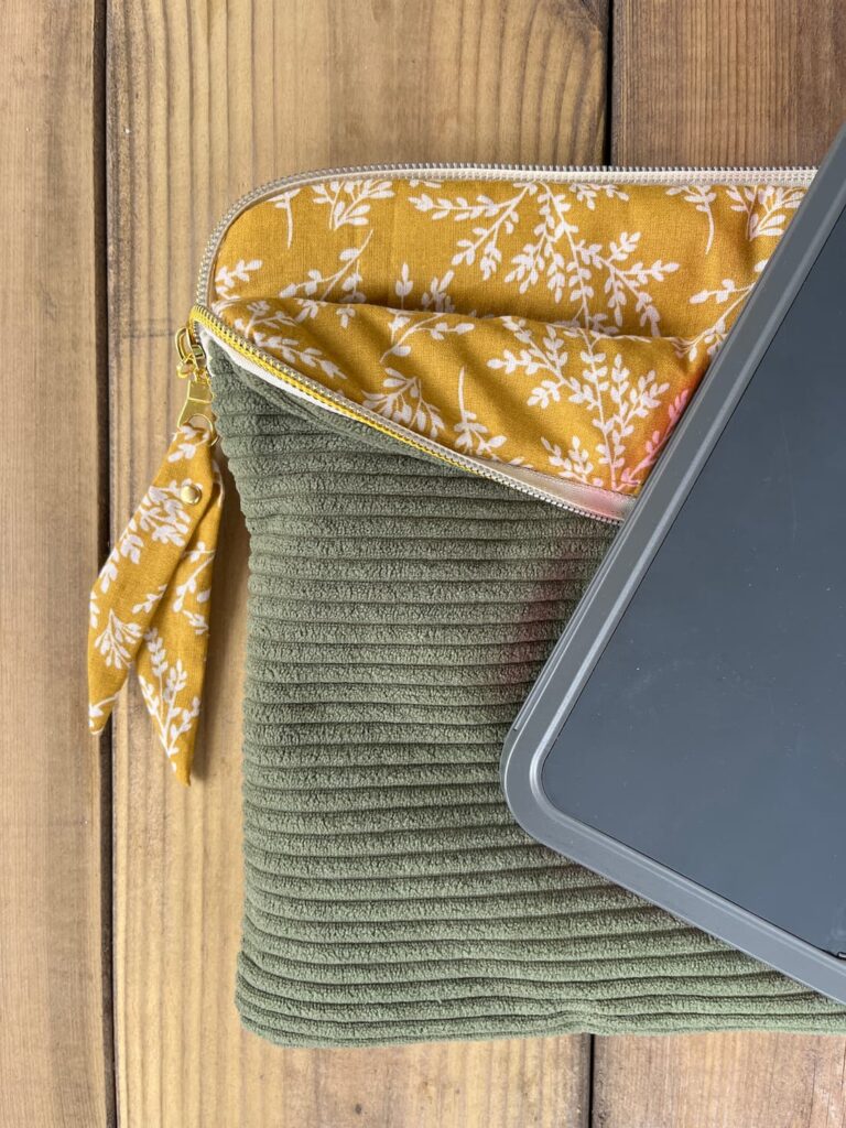 Insertion d'une tablette dans une housse matelassée vert d'eau à grande ouverture zippée